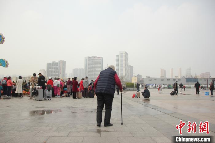 行走在郑州火车站西广场上的左春秀老人。　李明明 摄