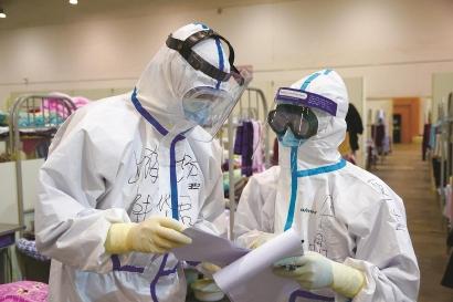 两名上海援助湖北医生讨论患者病情。 图片均为 郜阳 摄