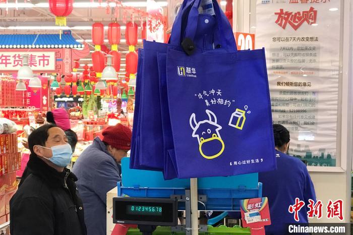 超市在醒目位置挂有无纺布购物袋供市民选购。 张亨伟 摄