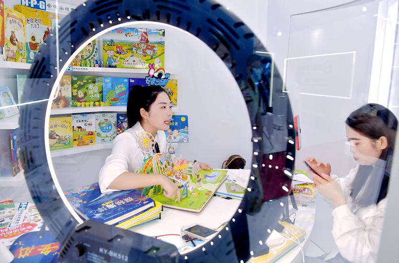 安徽出版集团展区工作人员通过直播的方式推荐少儿立体图书。.jpg