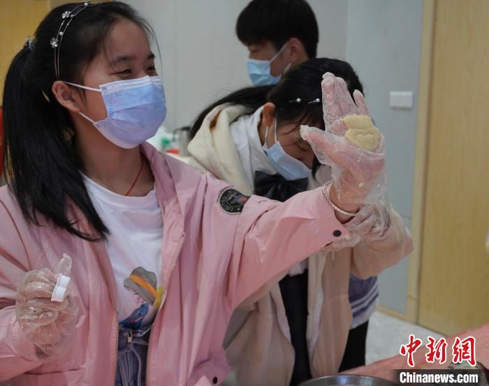 视障孩子向志愿者展示捏好的面团。 彭莉芳 摄