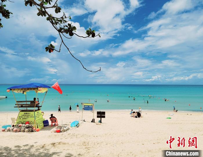 大东海景区,游客不惧中午阳光海边玩耍。 王晓斌 摄