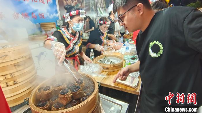 8月7日晚，福建旅游美食季主题活动上的畲族乌米饭吸引食客。　张丽君 摄